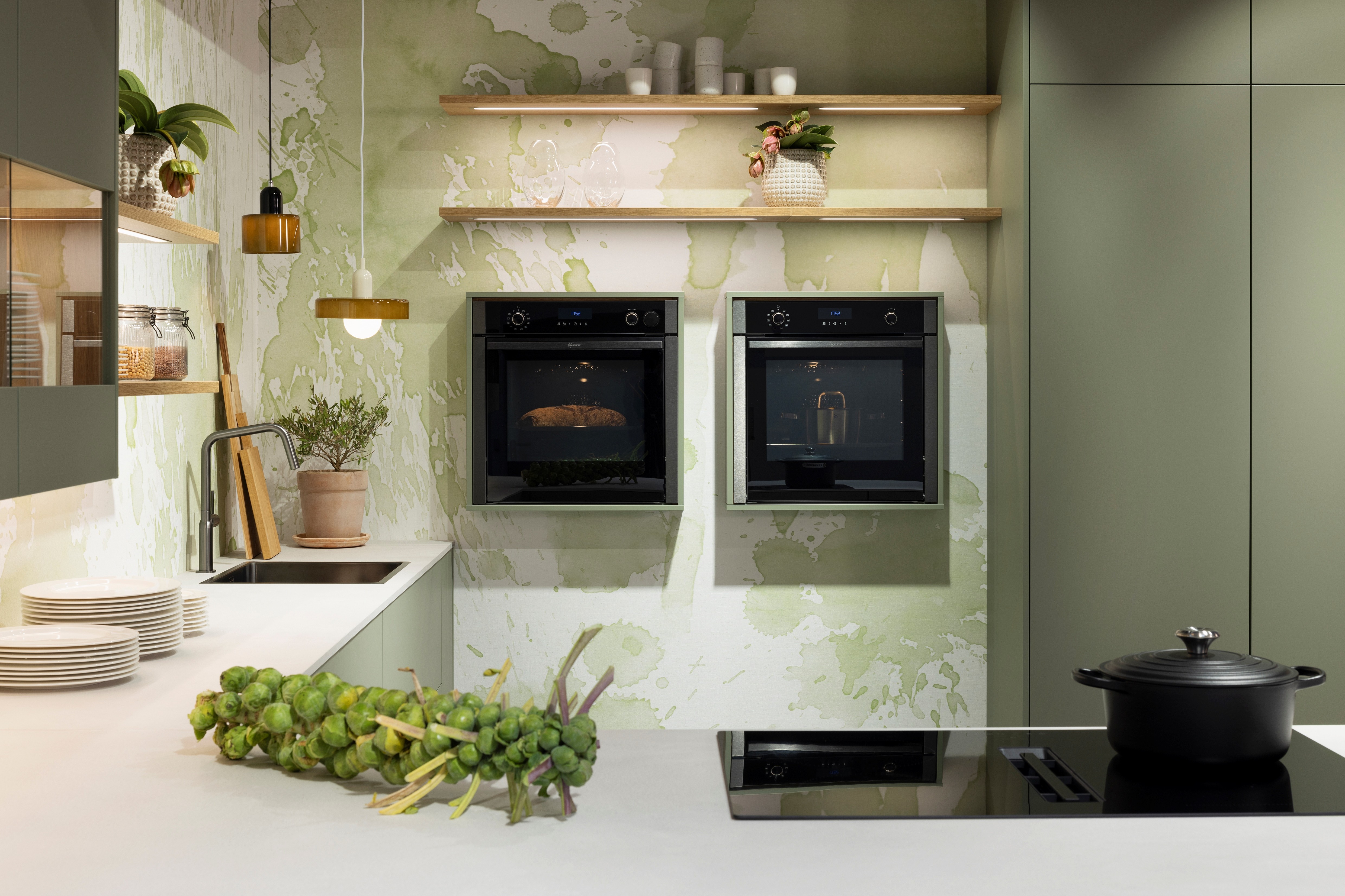 APL: 794 Beton Seidengrau NB (Xtra Ceramic) Korpus: 198 Eiche Sierra Front: Senso 495 Lack, Olive Premium matt Geräte: Neff Slide&Hide Armatur: Gessi Spüle: Teka Features: Trendfarbe Olive, Push to open, Tapete, neuer Schubkasten, Wandeinbau Backofen, beleuchtete Regale, beleuchtete Vitrinen, Weinflaschenregal, Schubkästen und Korpus in Eiche Sierra, Premium matte Oberfläche mit Antifingerprint, Nischenrückwand in Rillenoptik.